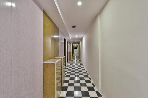 einen Flur mit schwarz-weiß kariertem Boden in der Unterkunft Hotel O Mayura in Ankleshwar