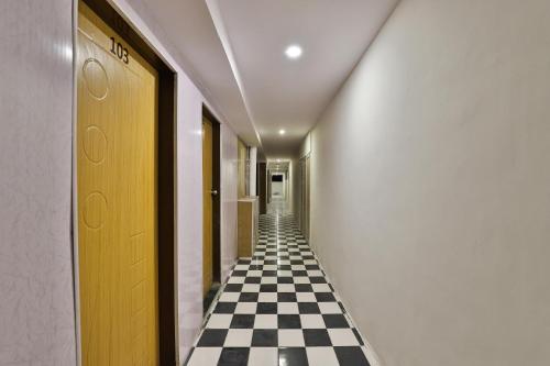 ein Flur mit schachbrettartigem Boden und einem durchgehenden Korridor in der Unterkunft Hotel O Mayura in Ankleshwar