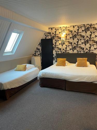 a hotel room with two beds and a window at Hotel Ajoncs d'Or in Saint Malo