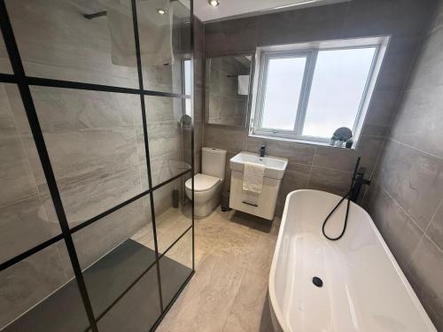 een badkamer met een douche, een toilet en een wastafel bij Dalton House - Private Parking in Blackpool