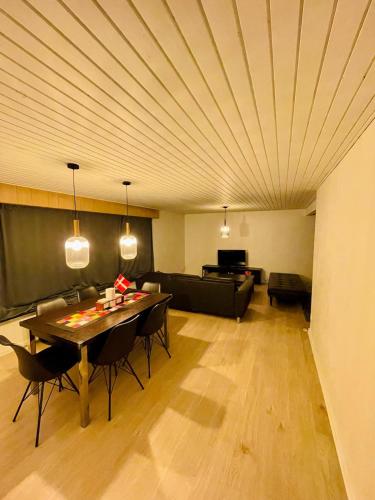a living room with a table and a couch at Family Villa, 2 min lalandia, Beach & Ferry, free parking, Fastest Fiber Internet in Rødby