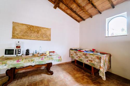 een keuken met 2 tafels en een magnetron bij Hotiday Grosseto Podere in Vacchereccia