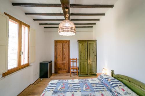 een slaapkamer met een bed en een hanglamp bij Hotiday Grosseto Podere in Vacchereccia