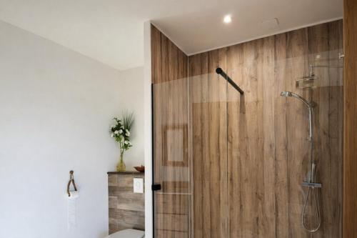 Chambre "Belle Etoile" Les Jardins de la Tuilerie في Faverolles: حمام مع دش مع جدار خشبي