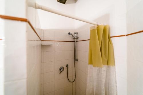 een douche met een geel douchegordijn in de badkamer bij Hotiday Grosseto Podere in Vacchereccia