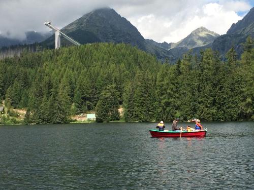 a group of people in a red boat on a lake at Apartman Panorama 805 in Štrbské Pleso