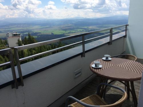 a table and chairs on a balcony with a view at Apartman Panorama 805 in Štrbské Pleso