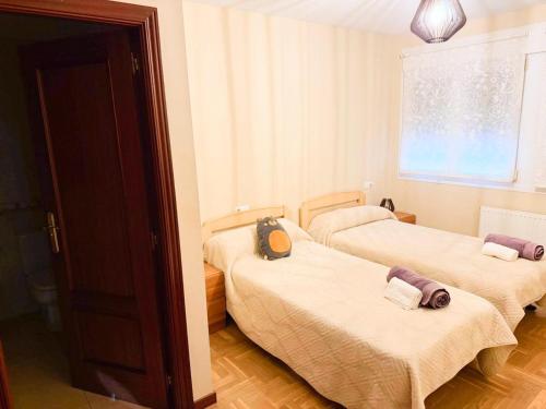 ein Zimmer mit zwei Betten und einem Fenster in der Unterkunft Cómodo apartamento con piscina by beBalmy in OVD