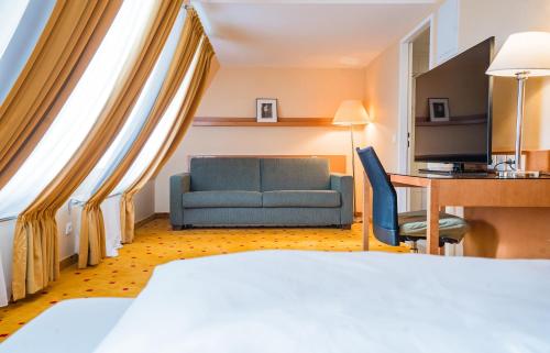 a hotel room with a bed and a chair and a desk at Ibercity Wien Schönbrunn in Vienna