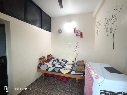 ein kleines Zimmer mit einem Bett und einer Waschmaschine in der Unterkunft guest house Akshay in Akalkot