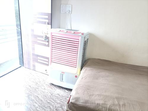 ein Zimmer mit Bett und Klimaanlage neben einem Fenster in der Unterkunft guest house Akshay in Akalkot