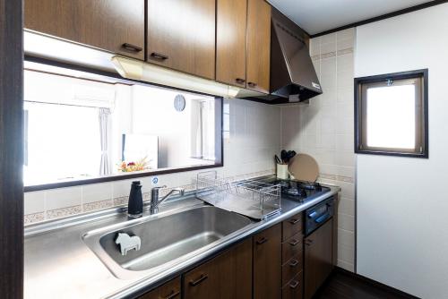 a kitchen with a stainless steel sink and a window at AMP FLAT MOMOCHi in Fukuoka