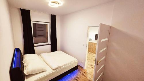 a small room with a bed and a mirror at GOLD APARTAMENT Ząbki in Ząbki