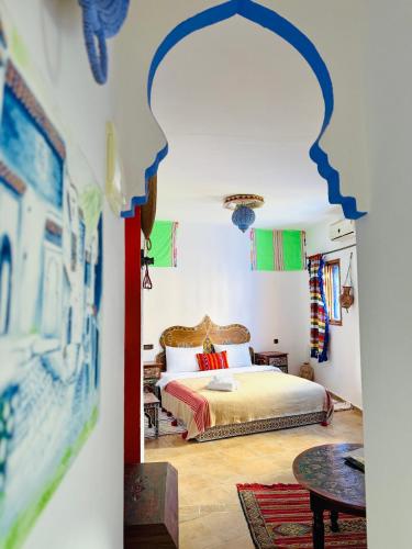 a bedroom with a bed and a table at Casa Blue Star in Chefchaouen