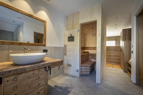 a large bathroom with a sink and a tub at Tieja Panoramic Lodge in Selva di Val Gardena
