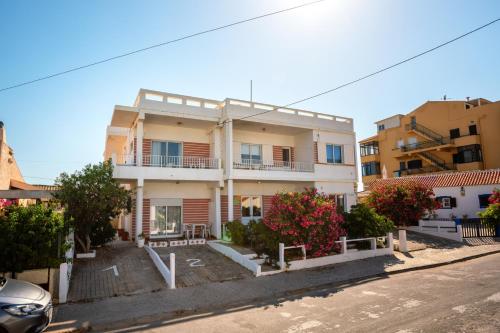 a large white building with balconies on a street at Blife Petrya private rooms at Faro beach in Faro