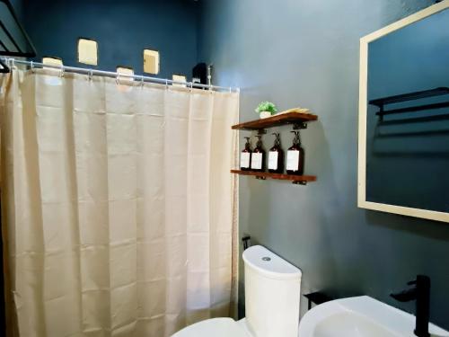 een badkamer met een douchegordijn en een toilet bij Villas Flora Bella Resort in Dauis