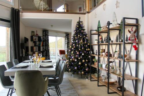 a dining room with a christmas tree and a table at Le Clos des Cigognes - Architect-designed house near Omaha Beach in Trévières