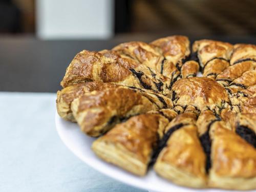 a pile of pastries on a plate on a table at ibis Styles Confins Aeroporto in Lagoa Santa