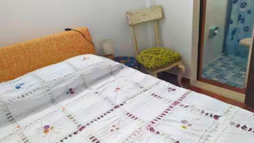 een bed met een wit dekbed in een kamer bij Un Café en el camino Guesthouse in Salento