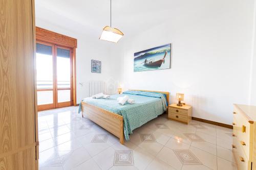 una camera da letto bianca con un letto e una finestra di Silver Bay Apartments a Porto Cesareo