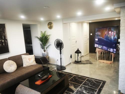 ein Wohnzimmer mit Sofa und Flachbildfernseher in der Unterkunft Nordic Elegance Villa in Uddevalla