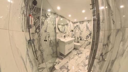 ein weißes Badezimmer mit Dusche und Waschbecken in der Unterkunft Nordic Elegance Villa in Uddevalla