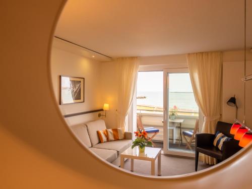 Una sala de estar con un sofá y vista al mar. en Miramar, en Helgoland