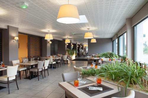 un restaurant avec des tables, des chaises et des fenêtres dans l'établissement L'Espadon, à Saint-Jean-de-Monts
