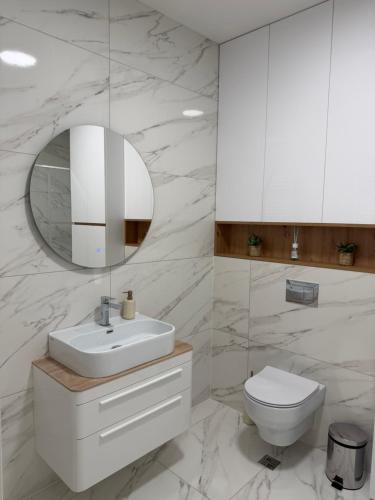 a bathroom with a sink and a toilet and a mirror at Palata Royal Banja Luka Luxury Apartment in Banja Luka