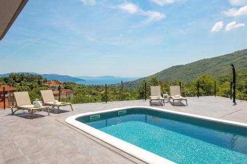 een zwembad met stoelen en uitzicht op een berg bij Villa Mantis by Briskva in Martina