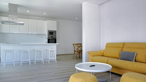 Una sala de estar con un sofá y una cocina. en Deva Beach Boutique Apartments, en San Fernando