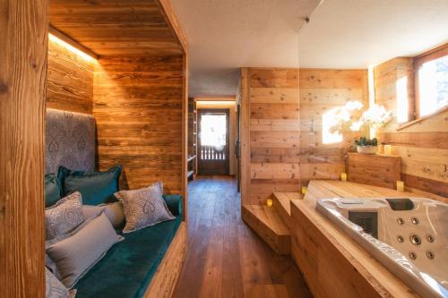 エトロウブレスにあるホテル ボー セジュールの木製の壁の客室で、バスタブが付いています。