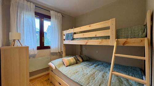 a bedroom with two bunk beds and a ladder at Flor de Hielo in Candanchú
