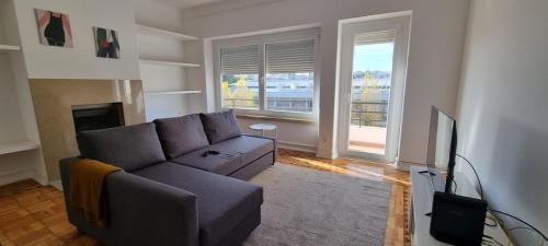 a living room with a couch and a tv at Rio de Janeiro 26 in Lisbon
