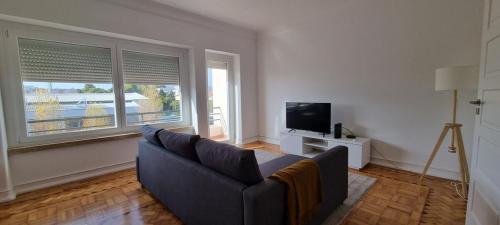 a living room with a couch and a tv at Rio de Janeiro 26 in Lisbon