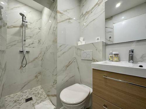 een witte badkamer met een toilet en een wastafel bij Palais du SOLEIL MONACO Terrasse & Parking in Beausoleil