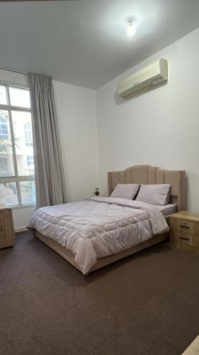 Un dormitorio con una cama grande con ventana. en Khalifa A Home Stay NR, en Abu Dabi