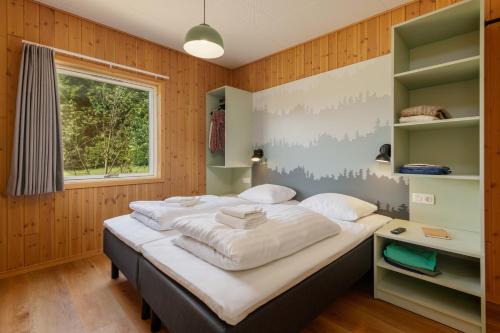a large bed in a room with a window at Center Parcs Nordborg Resort in Nordborg