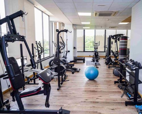 ein Fitnessstudio mit mehreren Laufbändern und einem blauen Ball in der Unterkunft Le Grand Hôtel de Thiès in Thiès