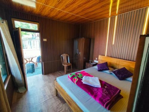 a bedroom with a large bed with purple pillows at Kanchenjunga Vista Pabong in Sāmthar