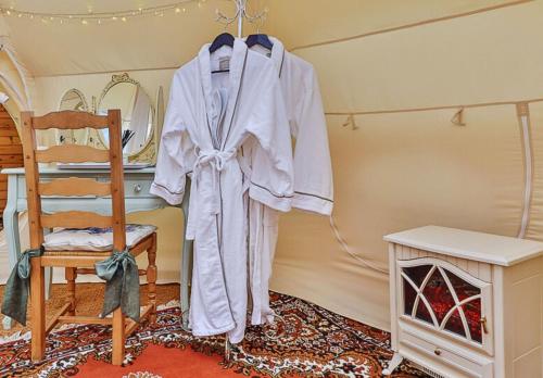 una veste appesa in una stanza con una sedia di Apple Blossom a Alkborough