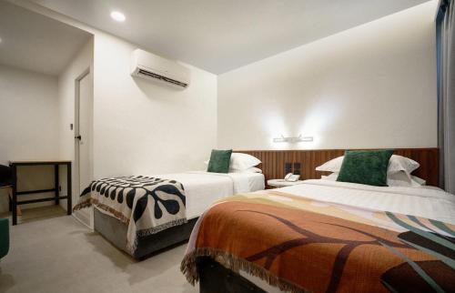 a hotel room with two beds with green pillows at Grand Inn Hotel in Bangkok