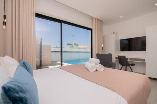 een slaapkamer met een groot bed met handdoeken erop bij Sirius House in Guia