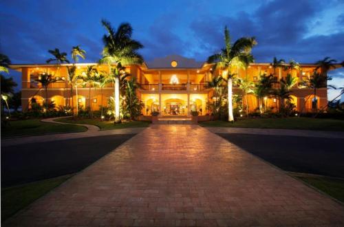 a large mansion with palm trees and a driveway at Villa Arrecife Community Pool w Ocean View in Dorado