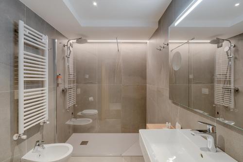 a bathroom with two sinks and a shower with two toilets at Alpen Hotel Vidi in Madonna di Campiglio