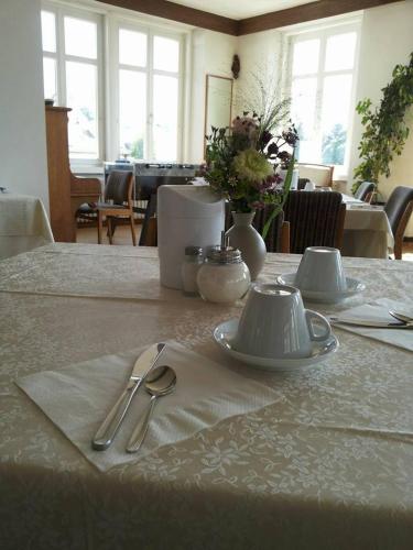 a table with plates and silverware on top of it at Gasthof Albergo Kreuzwirt in Fiè