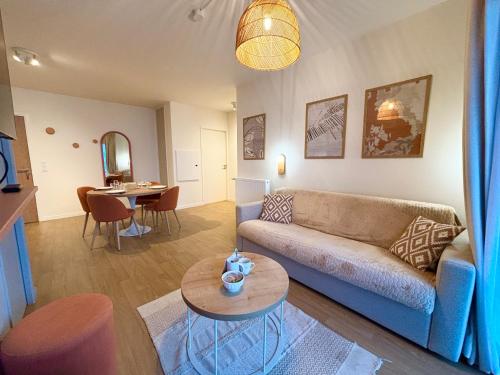 ein Wohnzimmer mit Sofa und Tisch in der Unterkunft L'Oranger bleu in Royan