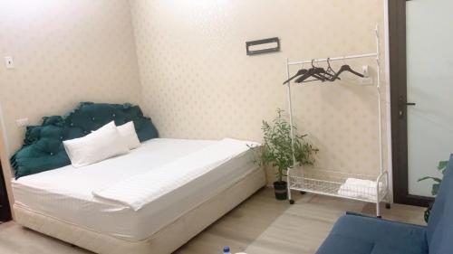 a bedroom with a white bed with a blue headboard at Bloom Homestay in Ninh Binh