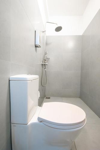 a white bathroom with a toilet and a shower at Kozy B&B in Mount Lavinia